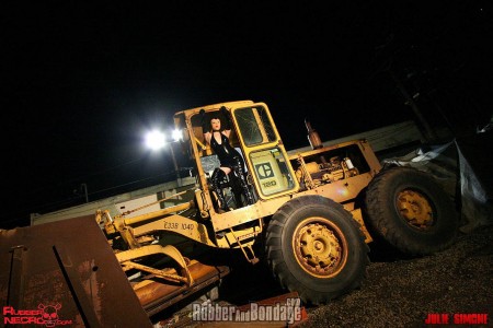 Tractor Pulled  High Def Version - Julie simone came up with this clever idea and executed it to perfection.  I am not sure how she got sandy skarsgard and a small crew into this construction yard but we are very glad she did.  I am all for latex clad, strictly bound women being able to enjoy the great outdoors but I am not sure that a b&e charge (thats breaking & entering for my foreign crowd) is the best way to go about it. Either way, our hats are off to julie for sniping this session in a closed off construction yard.  Sandy skarsgard was not necessarily a willing participant but she was able bodied and instructed to follow julies command when we put her out on loan.  Check out sandy in a combination of rubber, bondage and rope looking ultra-hot and helpless.  

we like that sandy gives a fight but her struggle was useless. Her wardrobe included a semi-transparent latex hood with black latex crown, a slinky latex dress that hikes up real nice to expose her pussy, sexy black thigh high boots and a really nice leather harness gag. The backdrop of the rugged exterior and heavy-duty rope bondage combined with the exposure of sandy's soft and delicate pussy really makes this one fun to watch. I cannot tell you how long sandy had to stay in that position but lets hope she was released well before the job foreman showed up. I am sure a band of construction workers could have put her to work in some creative way. Thanks again to julie simone for creating this update and be sure to visit her website under the same name.