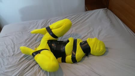 Simone Bumblebee Bound And Buzzed - Simone is encased in a yellow zentai, corseted and collared, and then taped up tight. She squirms around a bit and then says she wishes her legs were tied spread apart.. Her wish was my command.. She puts on a very sexy struggle and then asks for the wand vibe.. I bit gag her over her hood and proceed to give her some extra attention. She went veteran on her first shoot..